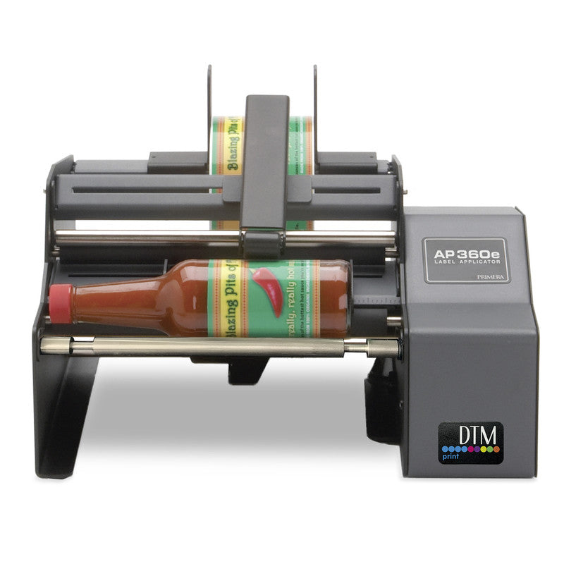 DTM AP360e round bottle label applicator with a hot sauce bottle, front view